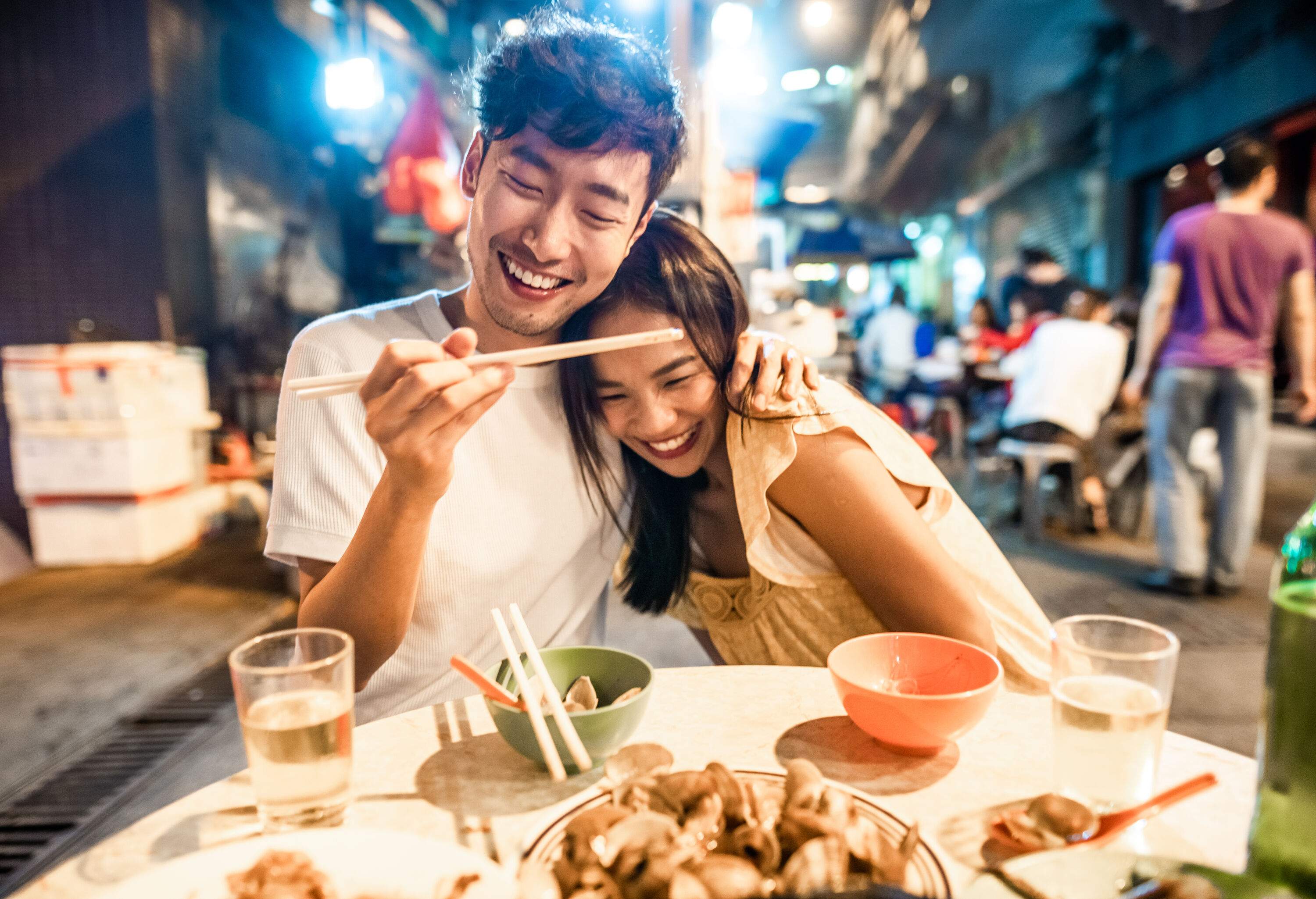 Asian couple enjoying street food in Hong Kong