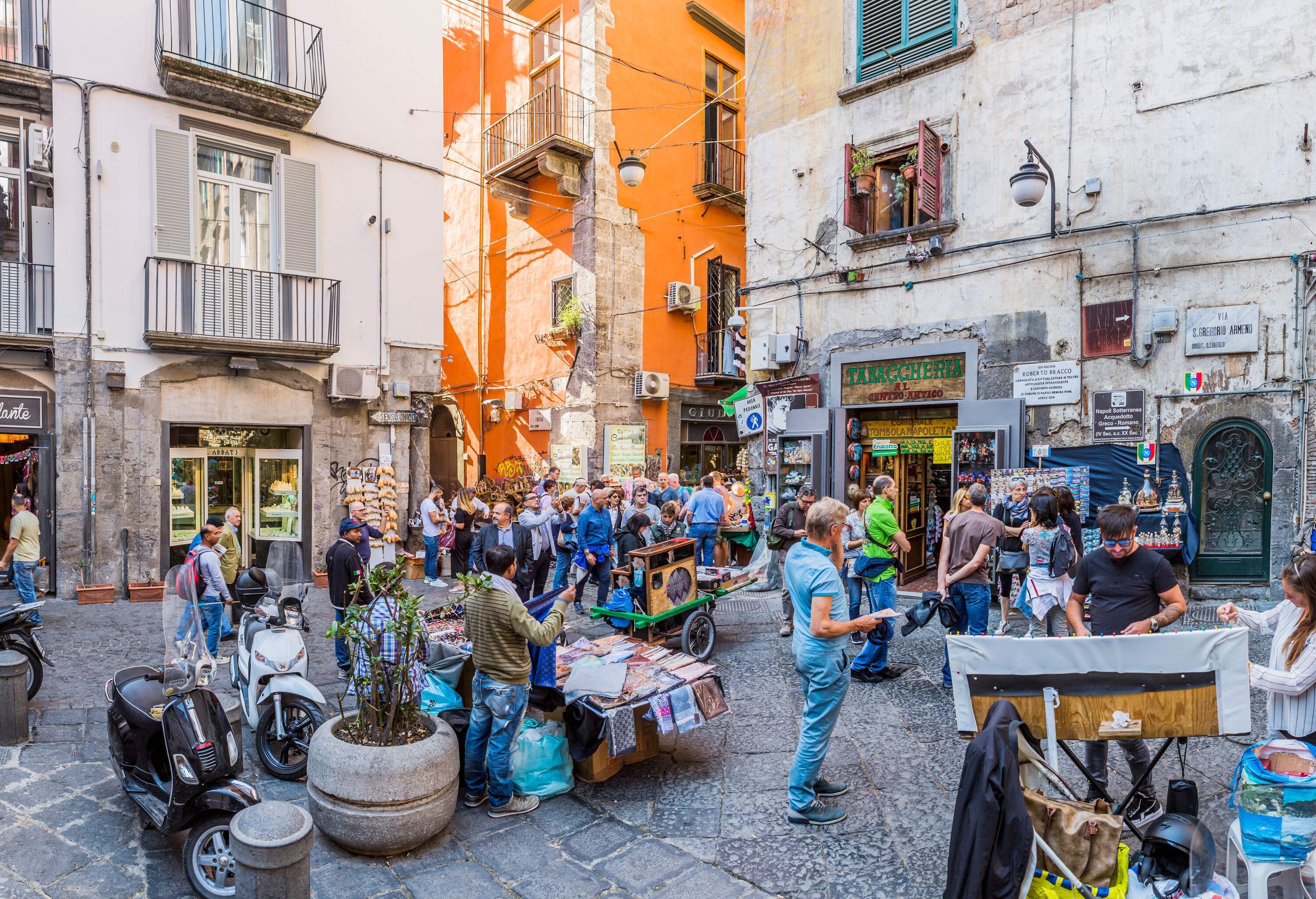 A bustling city square surrounded by traditional commercial buildings.