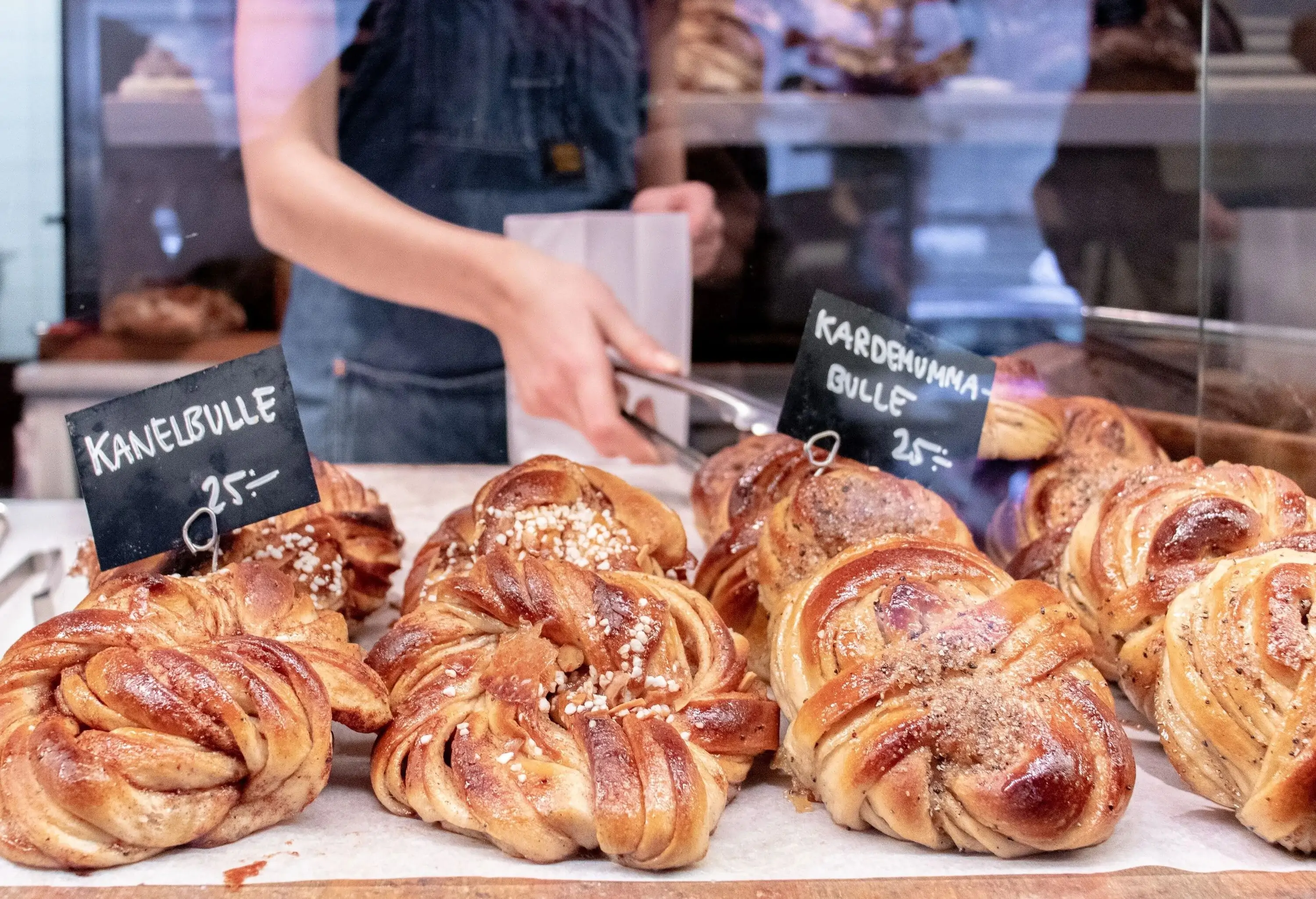 A display of baked cinnamon rolls with labels and pricing.