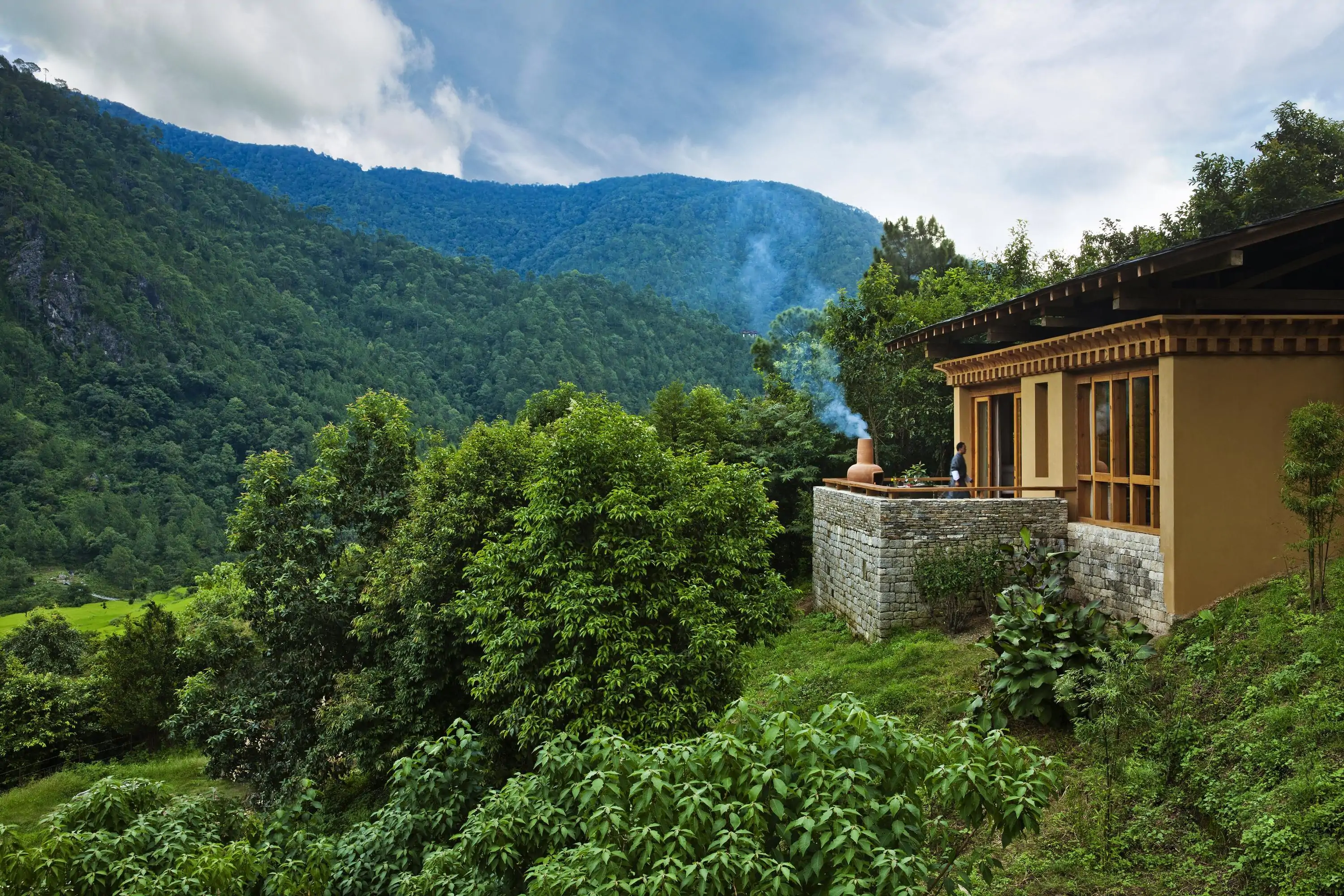 A luxury resort amaongst greenery with a stone fire pit being prepared